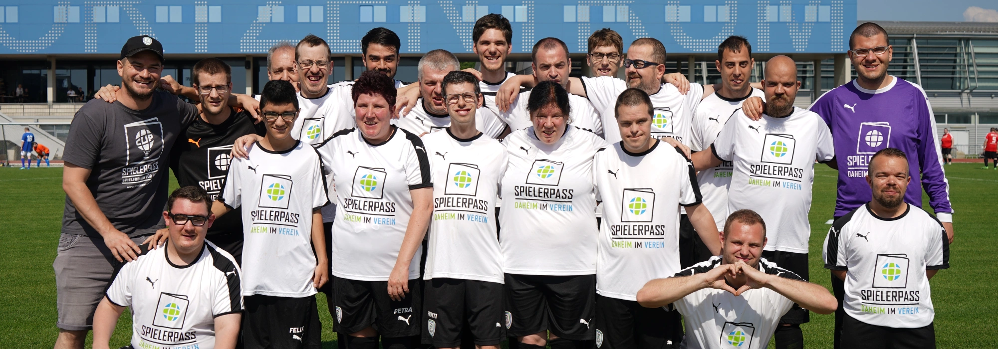 Das Champions-Team von SPIELERPASS stehend und kniend auf einem Fußballplatz in St.Pölten