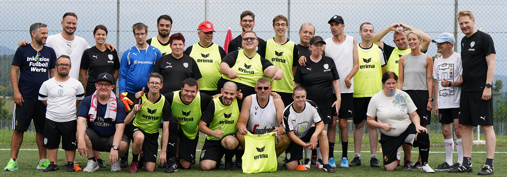 Gruppenfoto mit mehreren Personen stehend und kniend