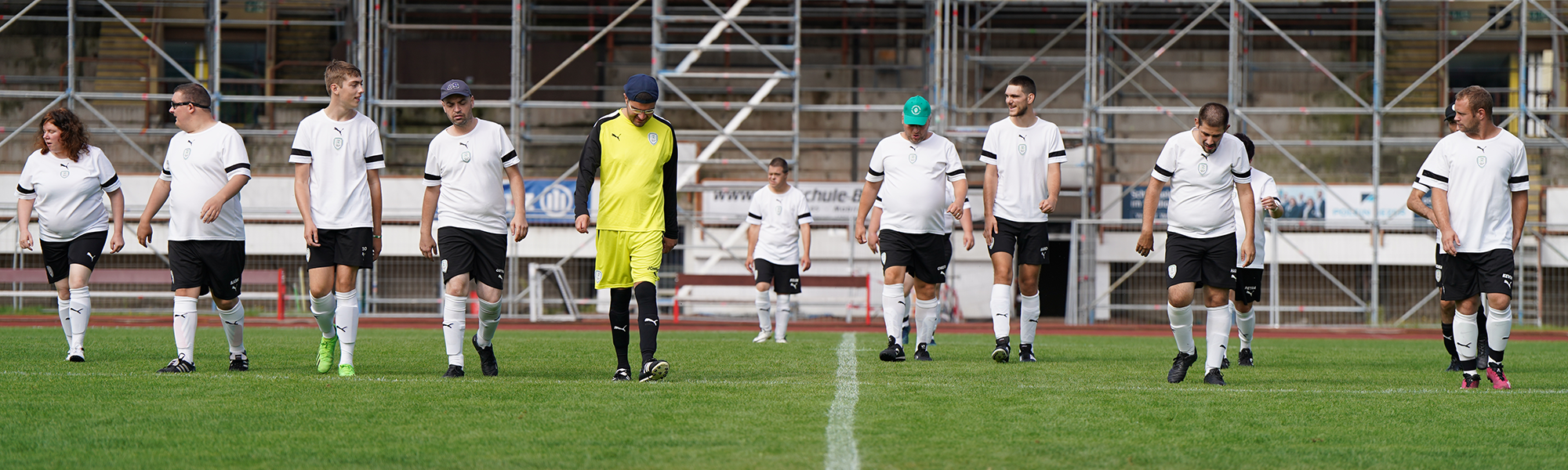 Spieler:innen der SPIELERPASS Champions nebeneinander gehend auf einem Fußballplatz